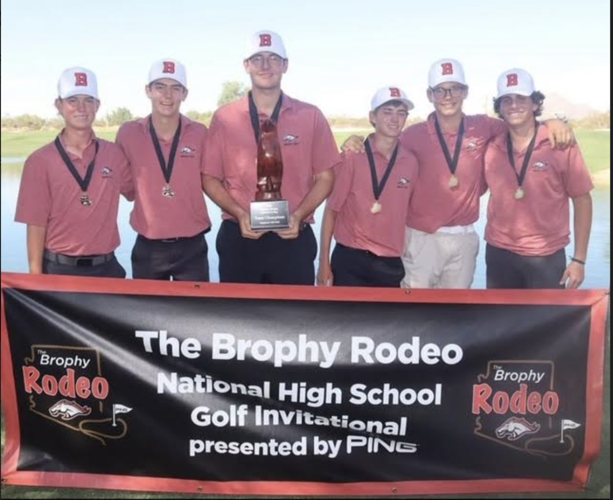 Golf team poses with trophy after winning the Brophy Rodeo